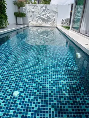 a swimming pool with a blue tile floor in a building at Lucky Villa Kamala in Kamala Beach