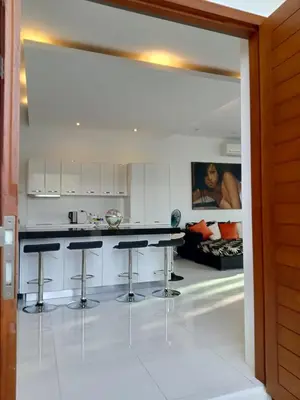 a kitchen with a counter and stools in it at Lucky Villa Kamala in Kamala Beach