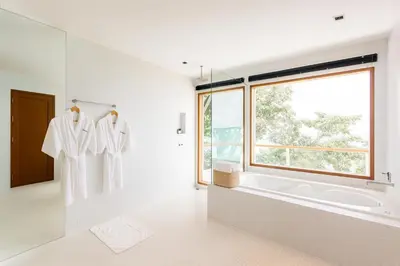 a white bathroom with a tub and a window at Villa Nevaeh - Ocean Front Private Villa Kamala Beach in Phuket Town