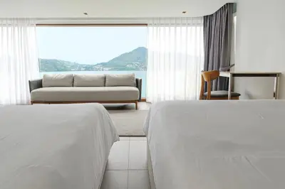 a hotel room with two beds and a couch at Villa Nevaeh - Ocean Front Private Villa Kamala Beach in Phuket Town