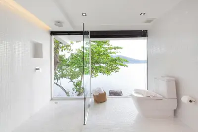 a bathroom with a shower and a toilet and a window at Villa Nevaeh - Ocean Front Private Villa Kamala Beach in Phuket Town