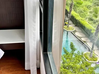 a view of a swimming pool from a window at Aristo Resort Surin Beach M18 in Phuket Town