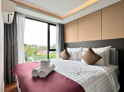 a bedroom with a bed with two teddy bears on it at Aristo Resort Surin Beach M18 in Phuket Town