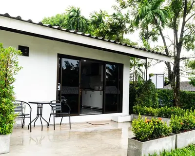 a patio with a table and chairs next to a house at Apollo Hotel Chalong in Ban Suan