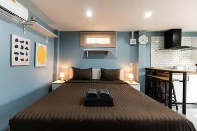 a bedroom with a bed with two shoes on it at Apollo Hotel Chalong in Ban Suan