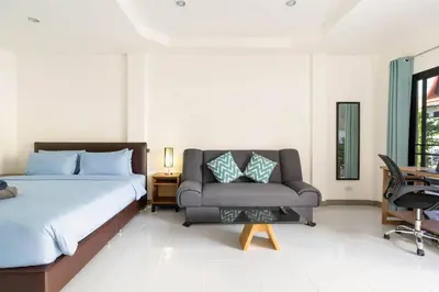 a bedroom with a bed and a couch and a chair at Kamala - Holiday Home - Studio Pool Access Bungalow in Kamala Beach