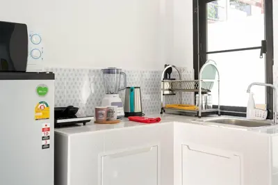 a kitchen with a refrigerator and a counter top at Kamala - Holiday Home - Studio Pool Access Bungalow in Kamala Beach