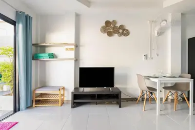 a living room with a television and a table and chairs at Kamala - Holiday Home - Studio Pool Access Bungalow in Kamala Beach