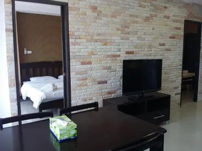 a living room with a tv and a mirror at Patong Tower by United 21 Thailand in Patong Beach