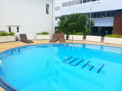 a large blue swimming pool in a hotel at Patong Tower by United 21 Thailand in Patong Beach