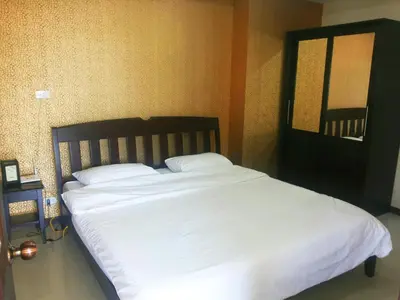 a bed with white sheets and pillows in a bedroom at Patong Tower by United 21 Thailand in Patong Beach