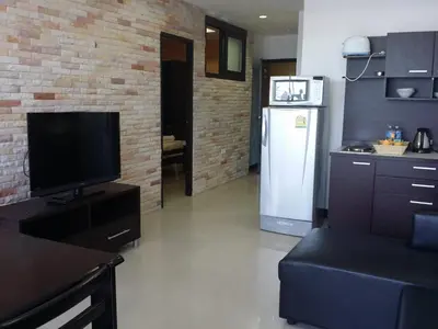a living room with a television and a refrigerator at Patong Tower by United 21 Thailand in Patong Beach