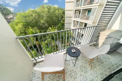 a balcony with two chairs and a table at The Title Residencies Nai Yang - 1 Bedroom Apartment in Nai Yang Beach