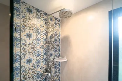 a bathroom with a shower with blue and white tiles at The Title Residencies Nai Yang - 1 Bedroom Apartment in Nai Yang Beach