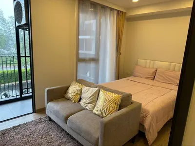 a bedroom with a bed and a couch and a window at Apartments in Skypark Laguna Bang Tao in Bang Tao Beach