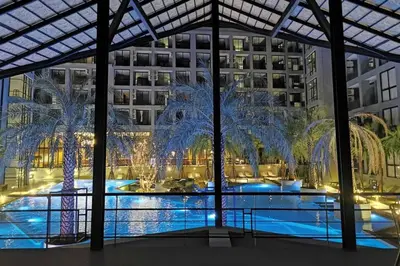 a large pool with palm trees in front of a building at Kamala Beach P73 Exclusive Junior Suite in Kamala Beach