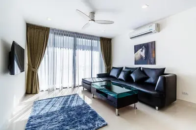 a living room with a black leather couch and a glass table at Phuket villa in Laguna Park in Bang Tao Beach
