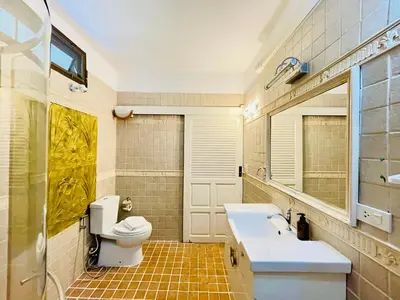a bathroom with a toilet and a sink and a mirror at Boomerang Village Resort Kata in Kata Beach