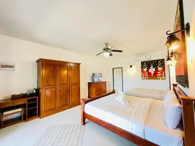 a bedroom with a bed and a dresser at Boomerang Village Resort Kata in Kata Beach