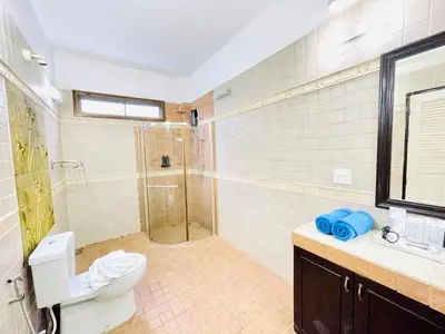 a bathroom with a shower and a toilet and a sink at Boomerang Village Resort Kata in Kata Beach