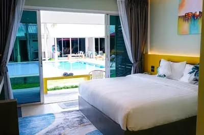 a bedroom with a bed and a view of a pool at Maiiam Bungalows Kata Beach in Kata Beach