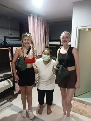 three women standing in a room with a woman wearing a mask at Lucky Guest House in Phi Phi Don