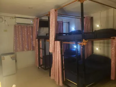 a room with two bunk beds with curtains at Lucky Guest House in Phi Phi Don