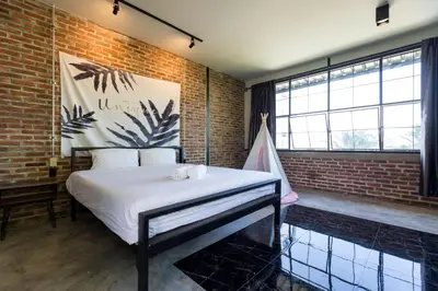 a bedroom with a bed in a brick wall at 9BR Neverland Loft Pool Villa in Ban Saiyuan (1)