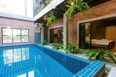 a swimming pool in a house with a brick wall at 9BR Neverland Loft Pool Villa in Ban Saiyuan (1)
