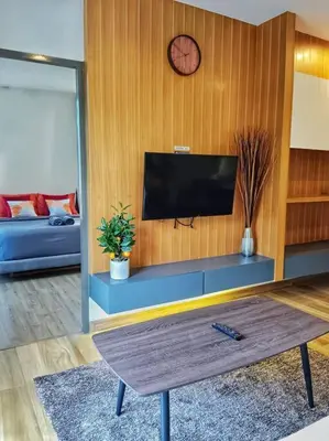 a living room with a flat screen tv on a wooden wall at Hill Myna Condo by Bcare - Two Bedrooms in Ban Thalat Choeng Thale