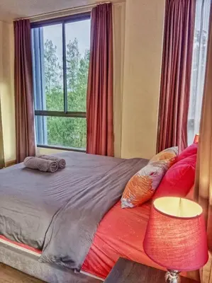 a bedroom with a large bed with a window at Hill Myna Condo by Bcare - Two Bedrooms in Ban Thalat Choeng Thale