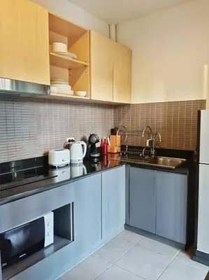 a kitchen with white cabinets and a sink at Hill Myna Condo by Bcare - Two Bedrooms in Ban Thalat Choeng Thale