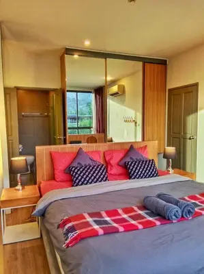 a bedroom with a large bed with red and blue pillows at Hill Myna Condo by Bcare - Two Bedrooms in Ban Thalat Choeng Thale