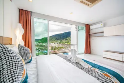 a bedroom with a bed and a large window at patong villa2：四卧泳池别墅/两个海景房/近班赞酒吧街 in Patong Beach