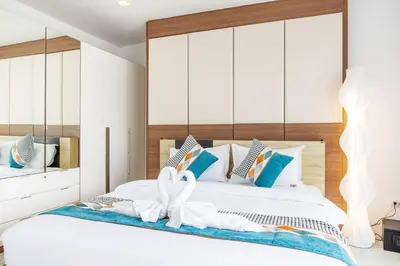 a bedroom with a white bed with a large headboard at patong villa2：四卧泳池别墅/两个海景房/近班赞酒吧街 in Patong Beach