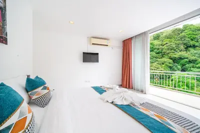 a bedroom with a bed and a window with a view at patong villa2：四卧泳池别墅/两个海景房/近班赞酒吧街 in Patong Beach