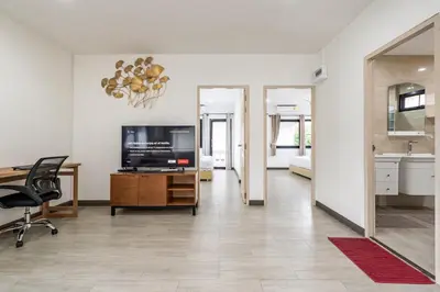 a living room with a flat screen tv and a desk at Kamala - 2 BR Pool View Apartment in Kamala Beach