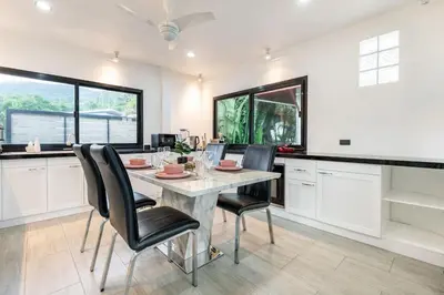 a dining room with a table and chairs at Kamala - 2 BR Pool View Apartment in Kamala Beach