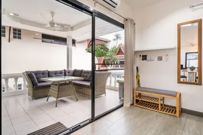 a living room with a couch and a table at Kamala - 2 BR Pool View Apartment in Kamala Beach