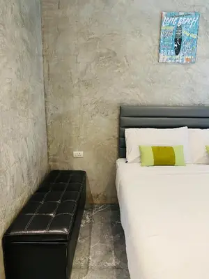 a bedroom with two beds and a leather couch at Malai Maikhao Near Beach in Ban Mai Salae