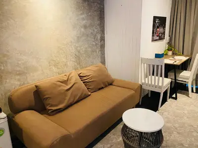 a living room with a couch and a table at Malai Maikhao Near Beach in Ban Mai Salae