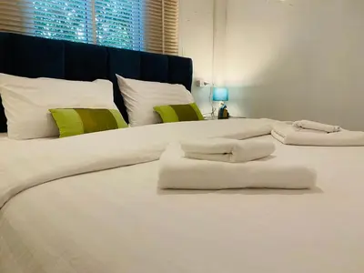 two large white beds with towels on top of them at Malai Maikhao Near Beach in Ban Mai Salae