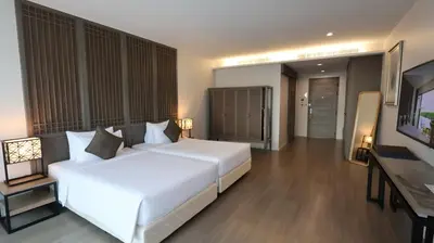 a bedroom with a large white bed and a television at Bella Nara Phuket Naiyang Beach in Nai Yang Beach