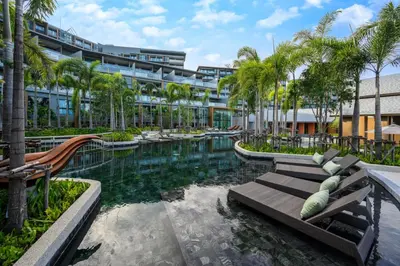 a resort with a pool and palm trees and a building at Luxury sea view apartment at Mida Grande Surin in Surin Beach