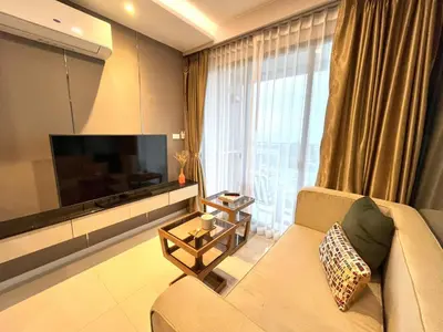 a living room with a couch and a flat screen tv at Luxury sea view apartment at Mida Grande Surin in Surin Beach