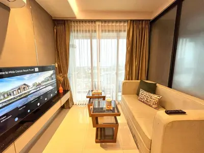 a living room with a couch and a large tv at Luxury sea view apartment at Mida Grande Surin in Surin Beach
