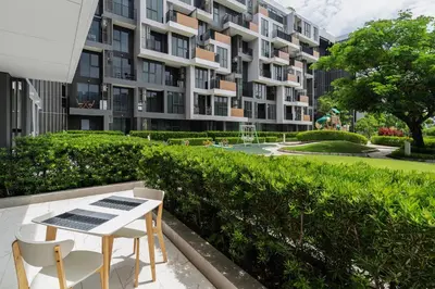 a apartment building with a table and chairs in front of it at 2 br Terrace Laguna, SkyPark in Thalang