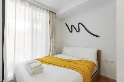a bedroom with a bed with two towels on it at 2 br Terrace Laguna, SkyPark in Thalang