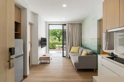 a living room with a couch and a table at 2 br Terrace Laguna, SkyPark in Thalang