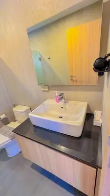 a bathroom with a sink and a toilet and a mirror at The Memories Hill Phuket in Thalang
